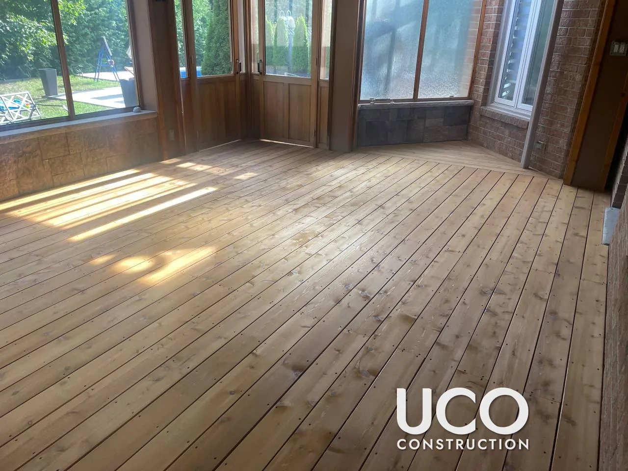 Cedar Deck and Sunroom Floor Restoration in Whitby: Weathered Cedar Boards Replaced Where Needed, Sanded and Stained Under a Pergola