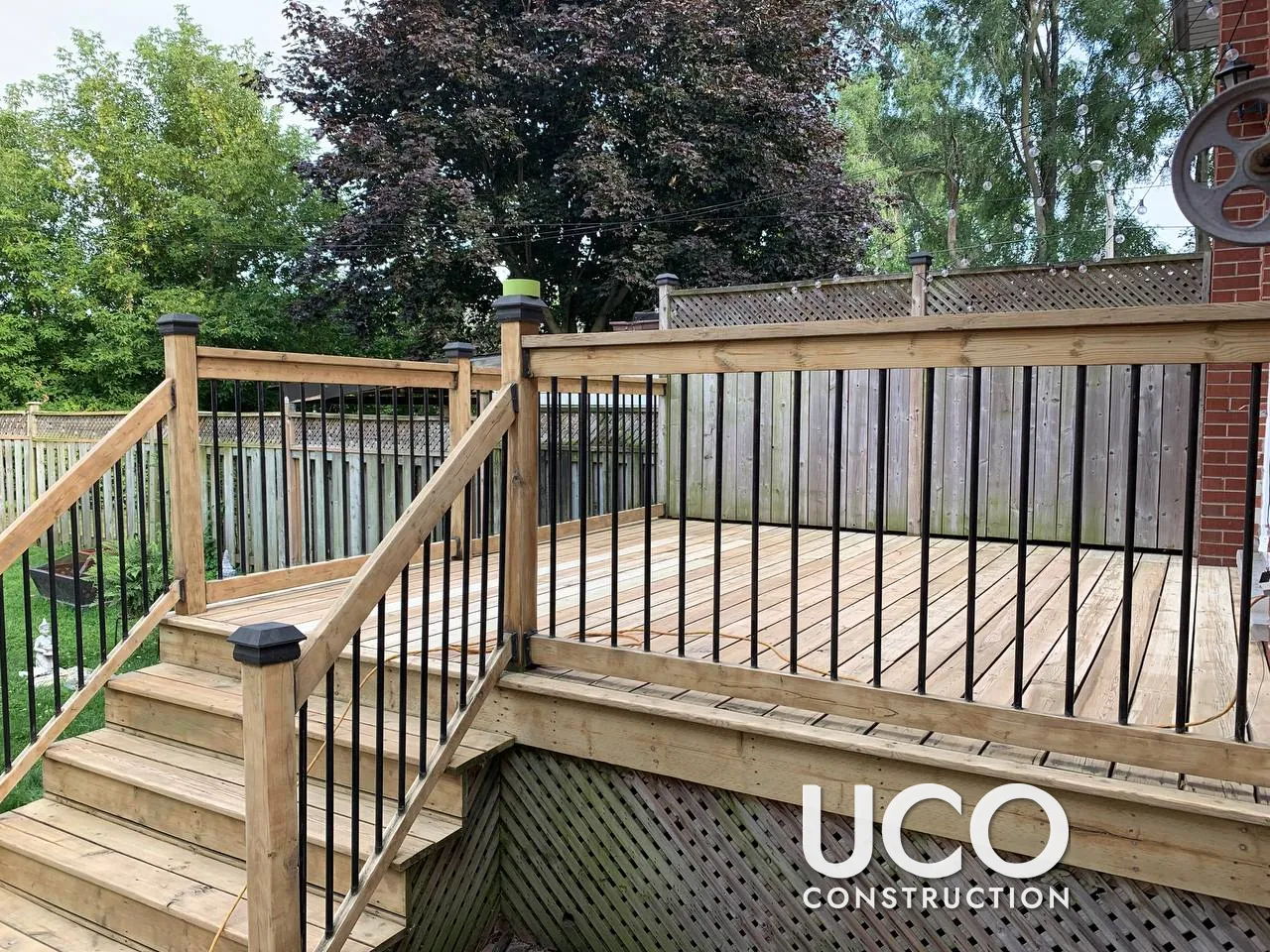 Deck Staining in Etobicoke: Raised Deck With Black Aluminum Balusters, Stairs and Lattice Skirting Sanded and Stained Cedar