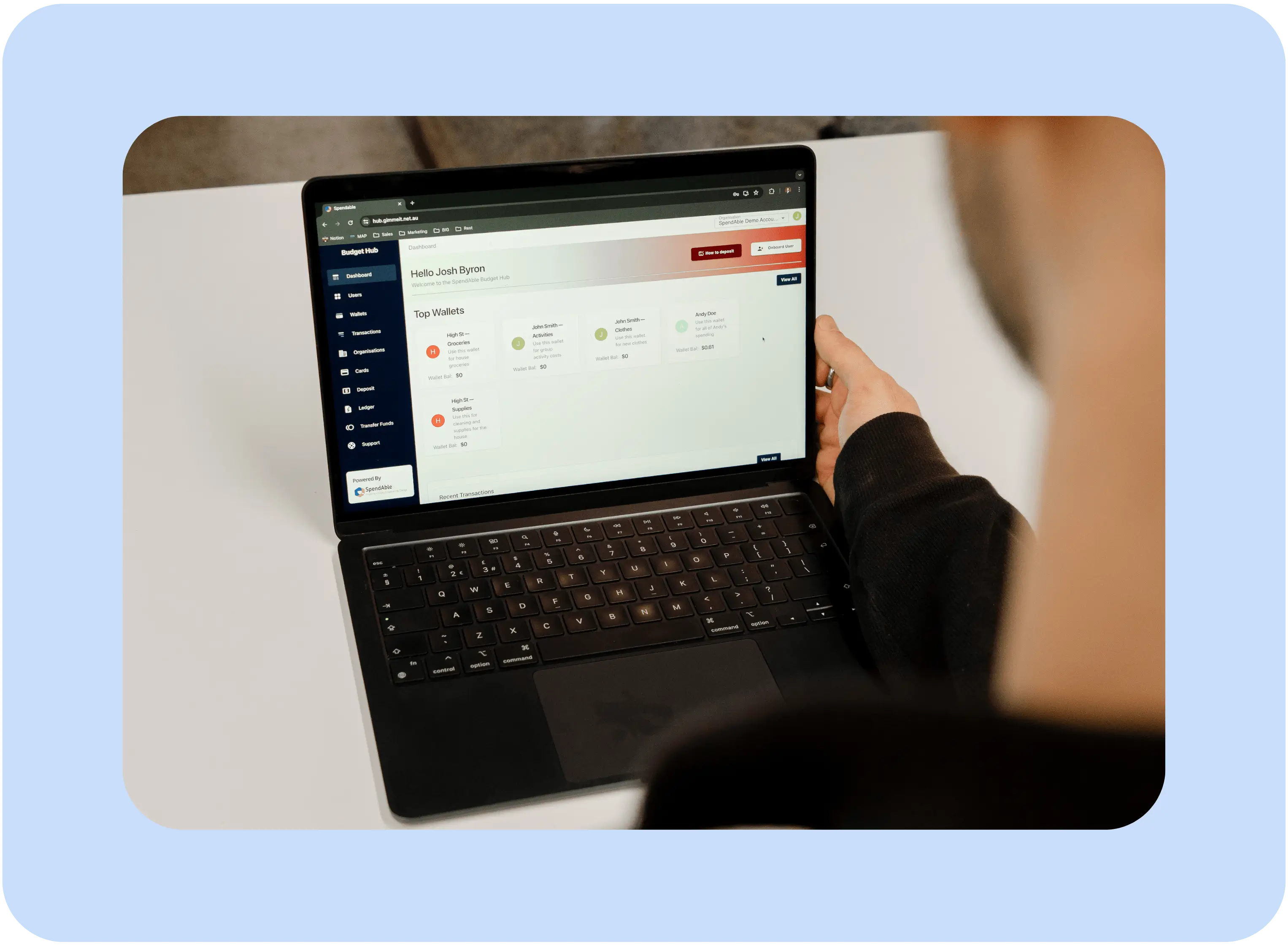 A person using a laptop to view wallets and budgets on the spendAble disability money management app dashboard.