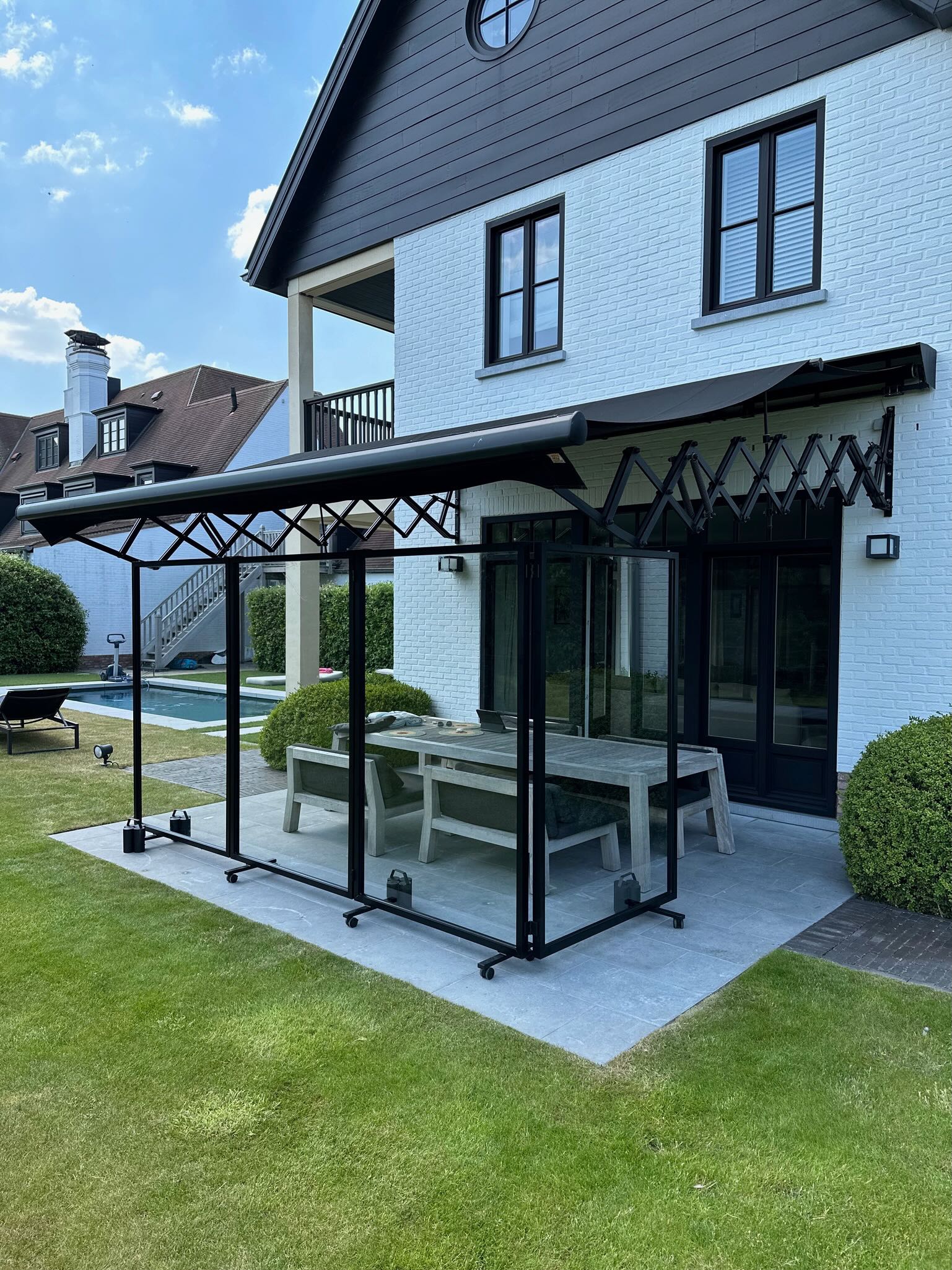 Paraconstruct - een mobiel windscherm in het zwart op een buitenterras 