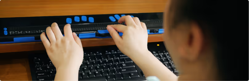 A person typing on a keyboard on a desk.