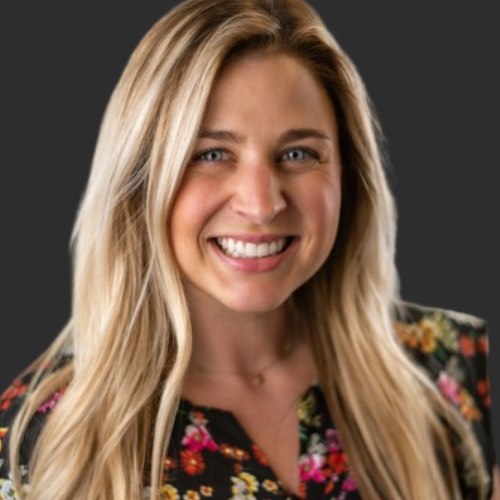 Smiling blond professional woman in a floral shirt.