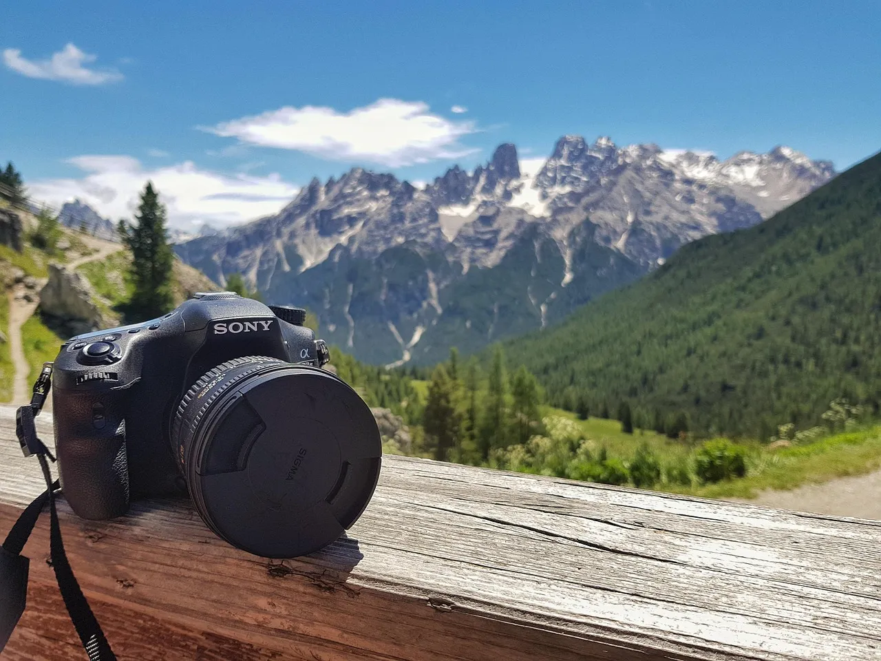 An image of a camera on a balcony overlooking the Dolomites.