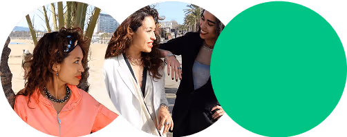 Tres mujeres sonrientes conversando al aire libre con un paisaje urbano al fondo.