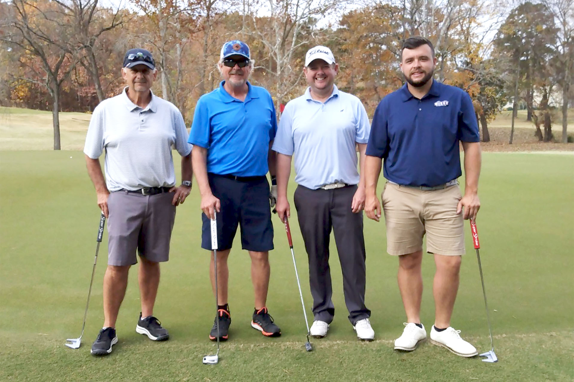 Jamestown Golf Association members driving to the next hole on a golf cart.