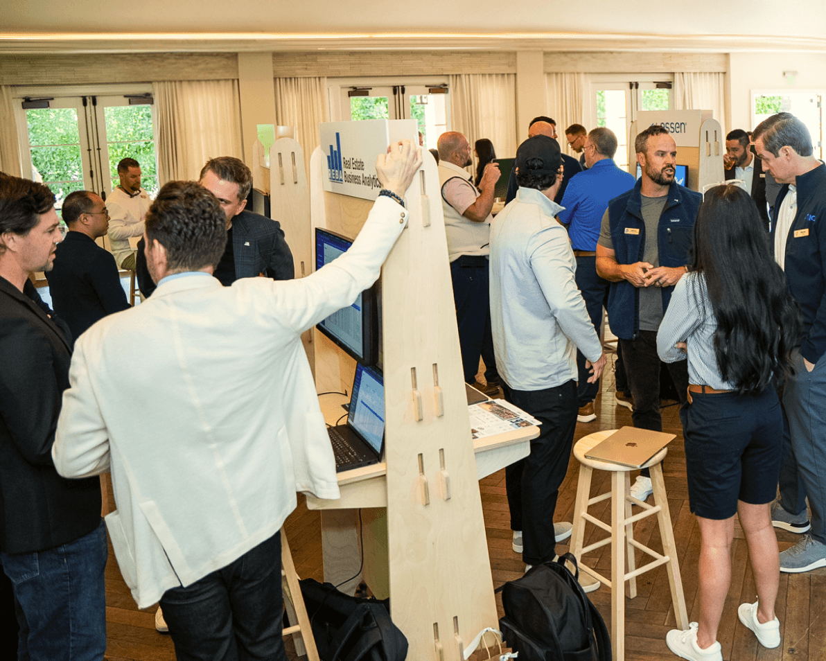 Attendees gathered around a sponsor kiosk at Happy Summit