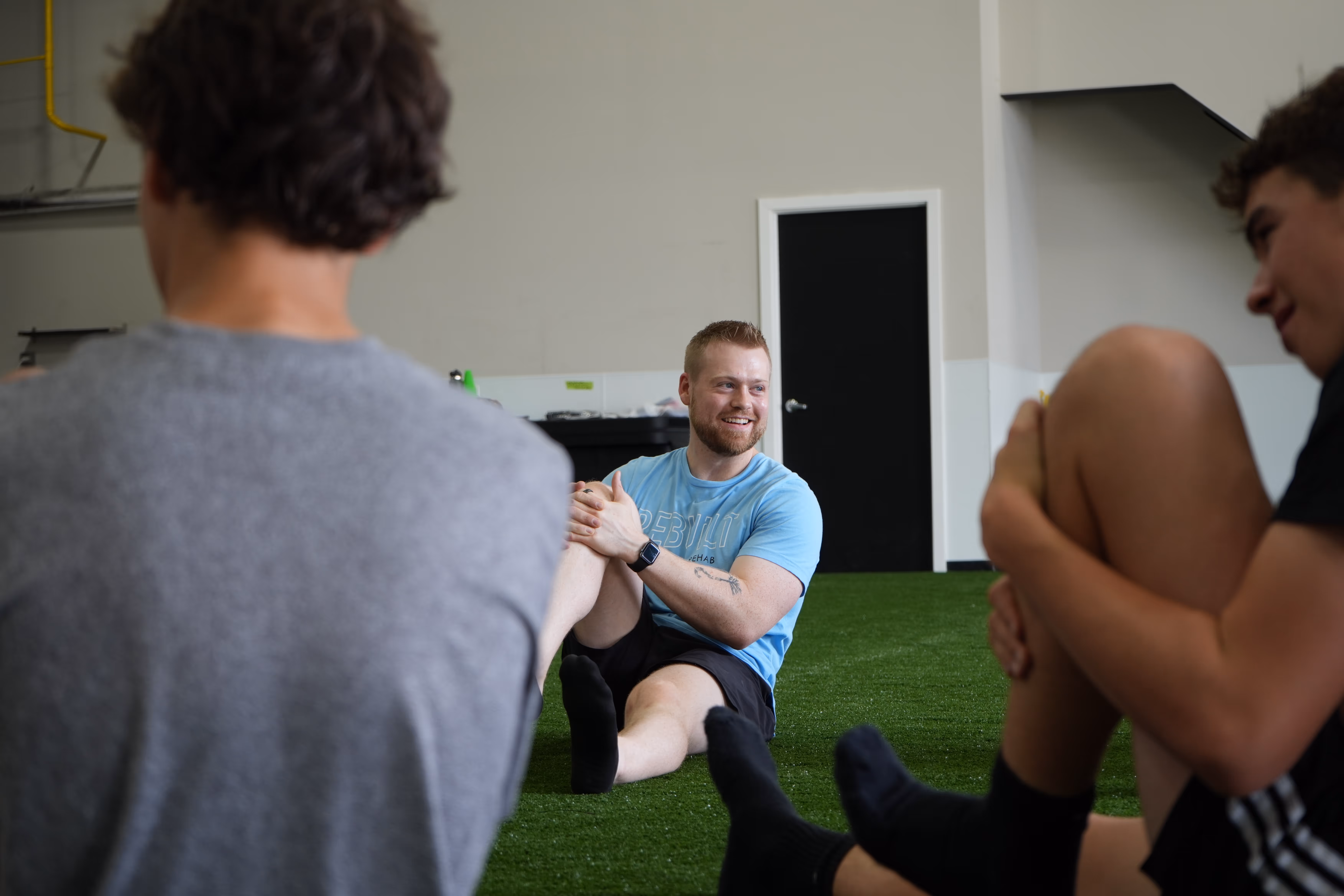 Kyle Richmond of REBUILT Performance stretching with students.