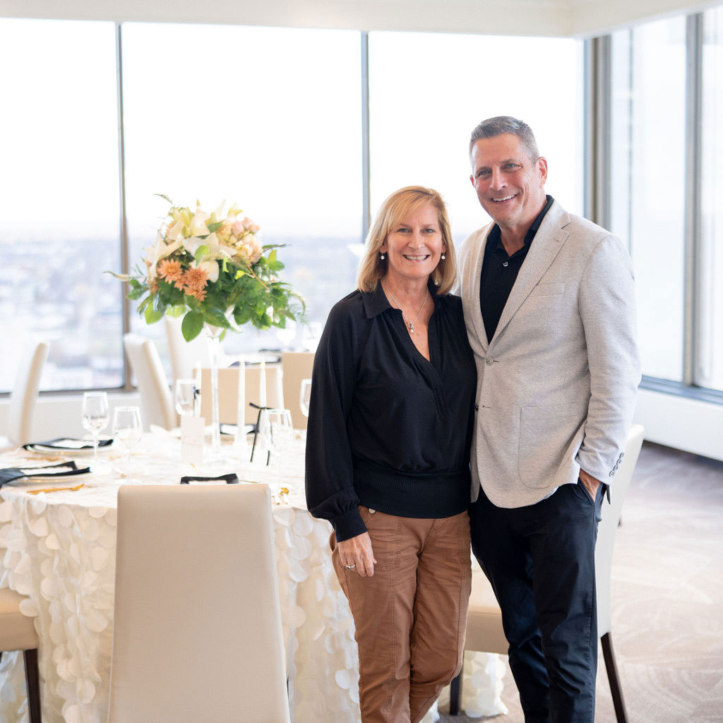 Two persons standing in front of a decorated table.
