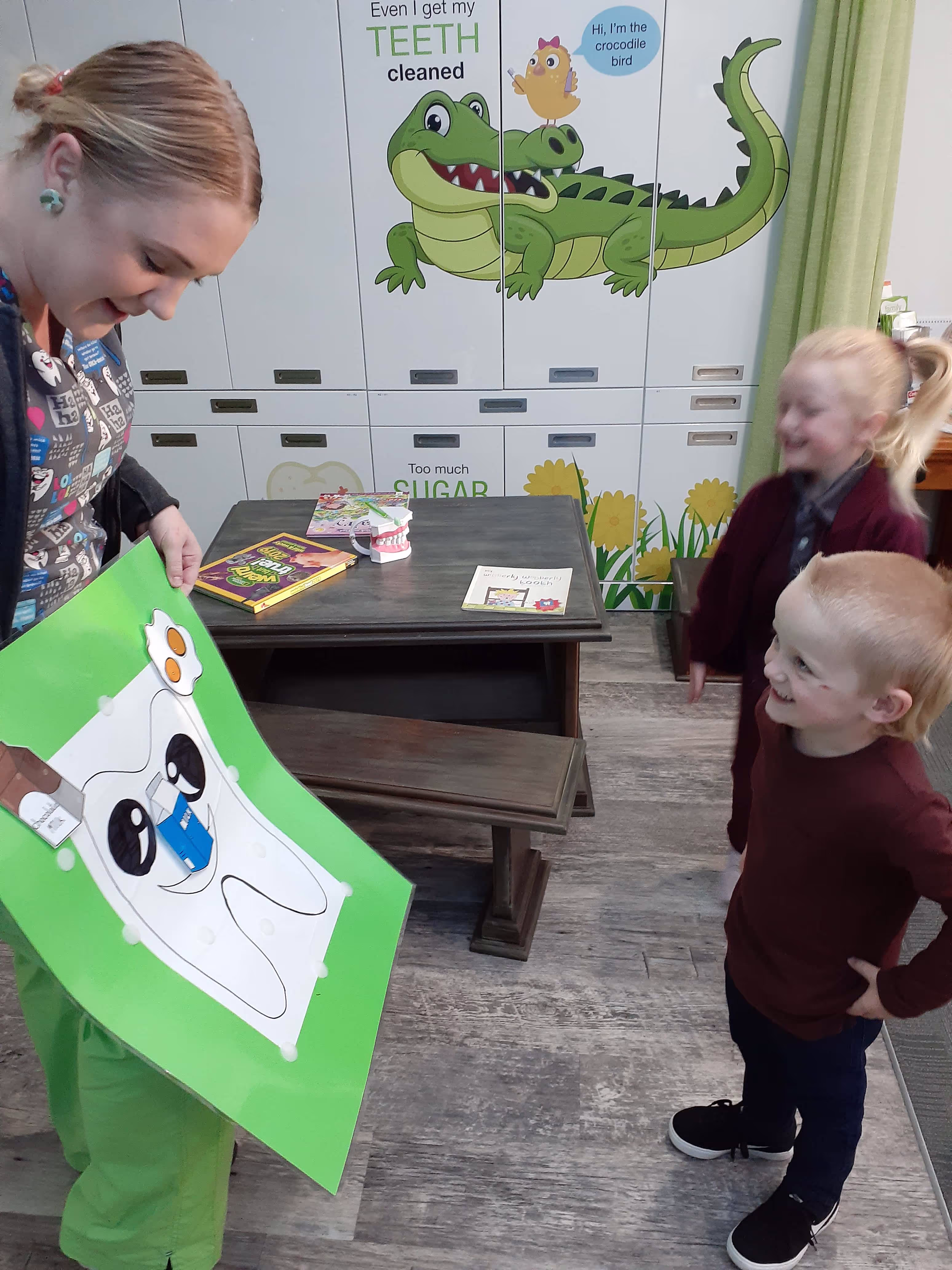 Dental nurse showing drawing to little kids in a dental surgery