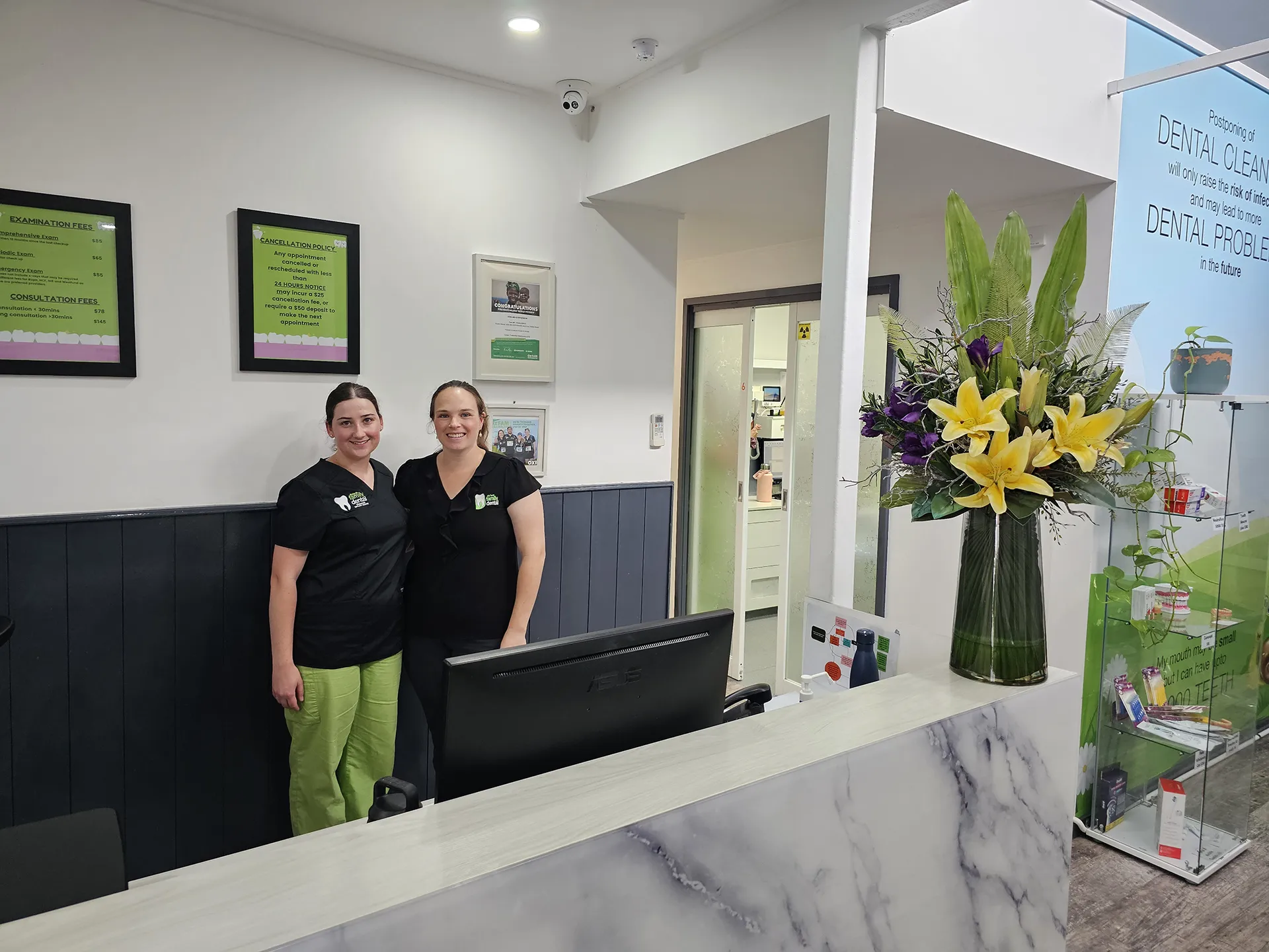 Two dental workers standing at reception