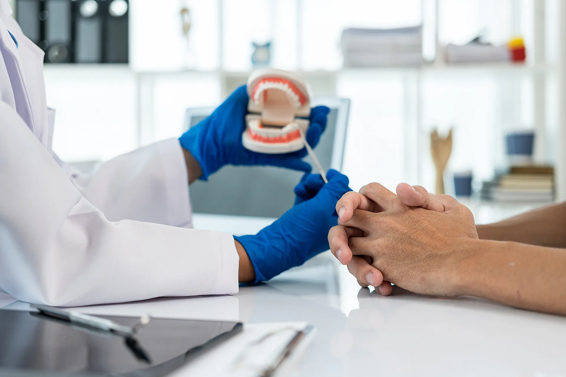 Dentist demonstrating on a tooth model to a patient