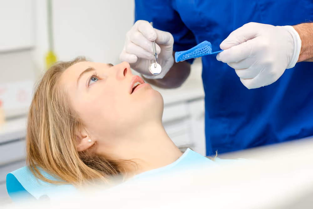 Woman getting mouthguard fitted at dentist