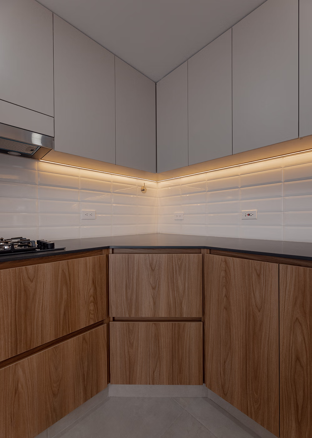 Lavamanos de piedra con grifería dorada, toalla blanca y espejo redondo en baño moderno.