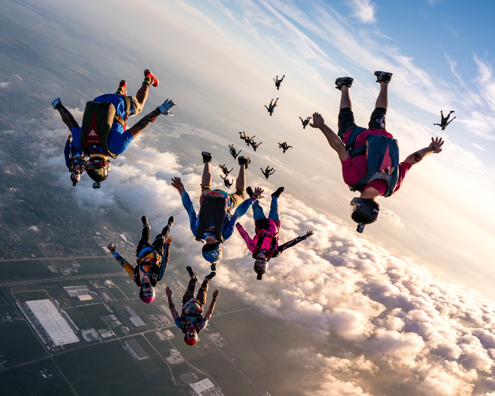 Formation of skydivers in freefall above the clouds