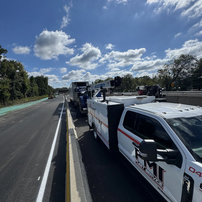 Wide image of a FMI Mobile truck servicing another truck on a freeway