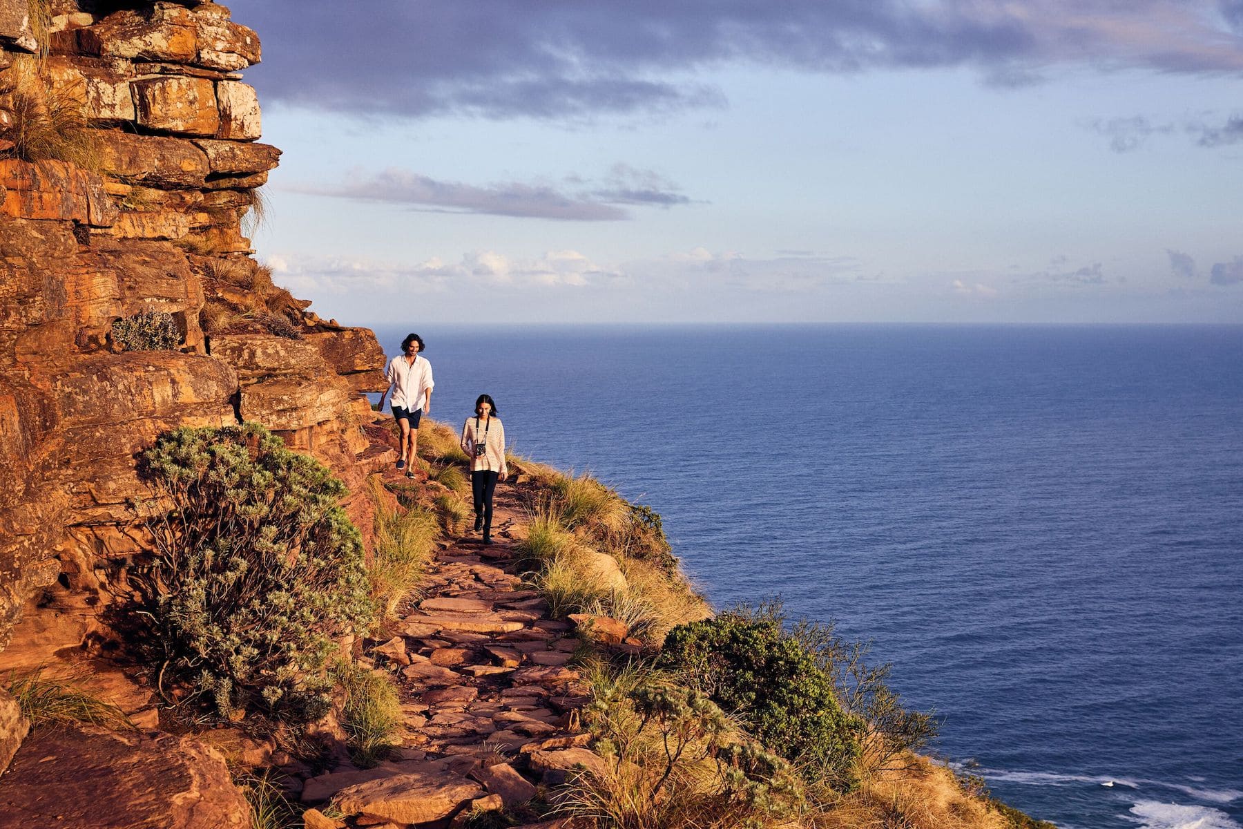 Couple walking on the edge of a cliff