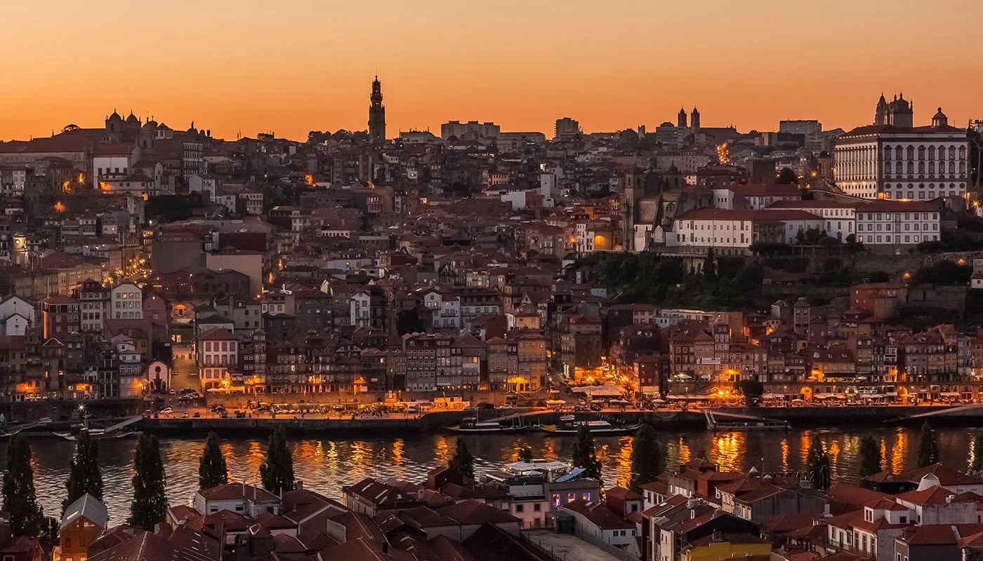 Porto's historic centre and rooftops at dusk, viewed across the Douro River