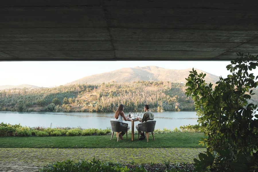 Couple dining beneath a raw-concrete terrace overlooking the Douro River at Octant Douro, northern Portugal