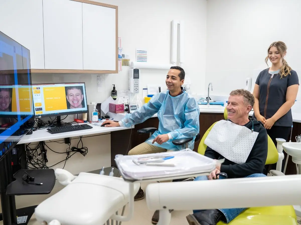 Dr Amit discusses dental implants treatment with a patient at Great Alpine Dental.