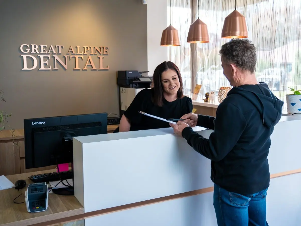 A patient discusses payment options for dental implants with a staff member at Great Alpine Dental.