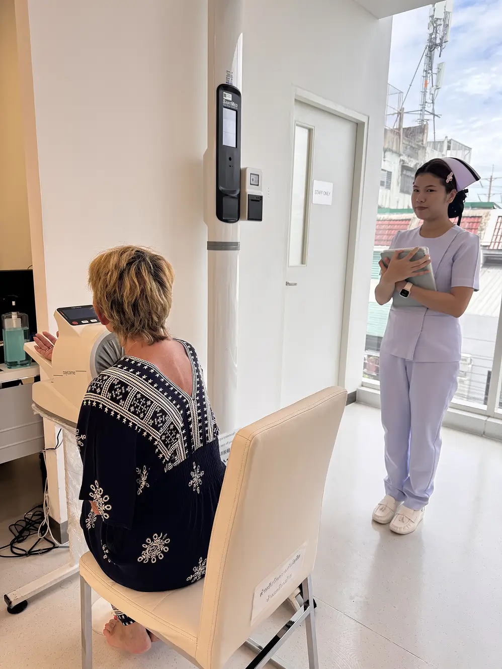 Nurse observing a patient during a medical examination at a clinic.