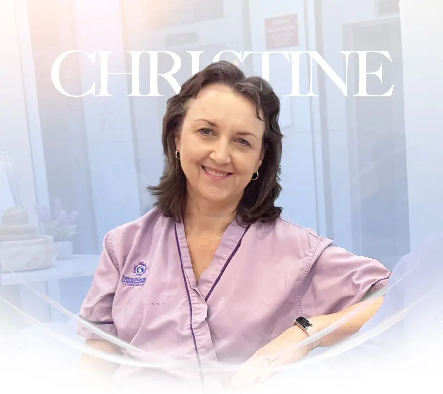 Smiling patient in a lavender uniform in a clinic setting.”