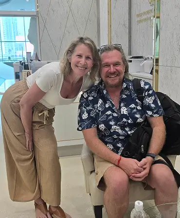 Lori and her husband Steve smiling together in the lobby of World Medical Hospital in Bangkok before her surgery.