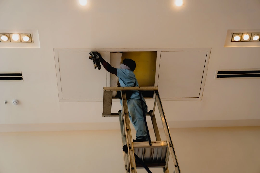 Technician inspecting an AC unit's internal components - signs your ac needs repair