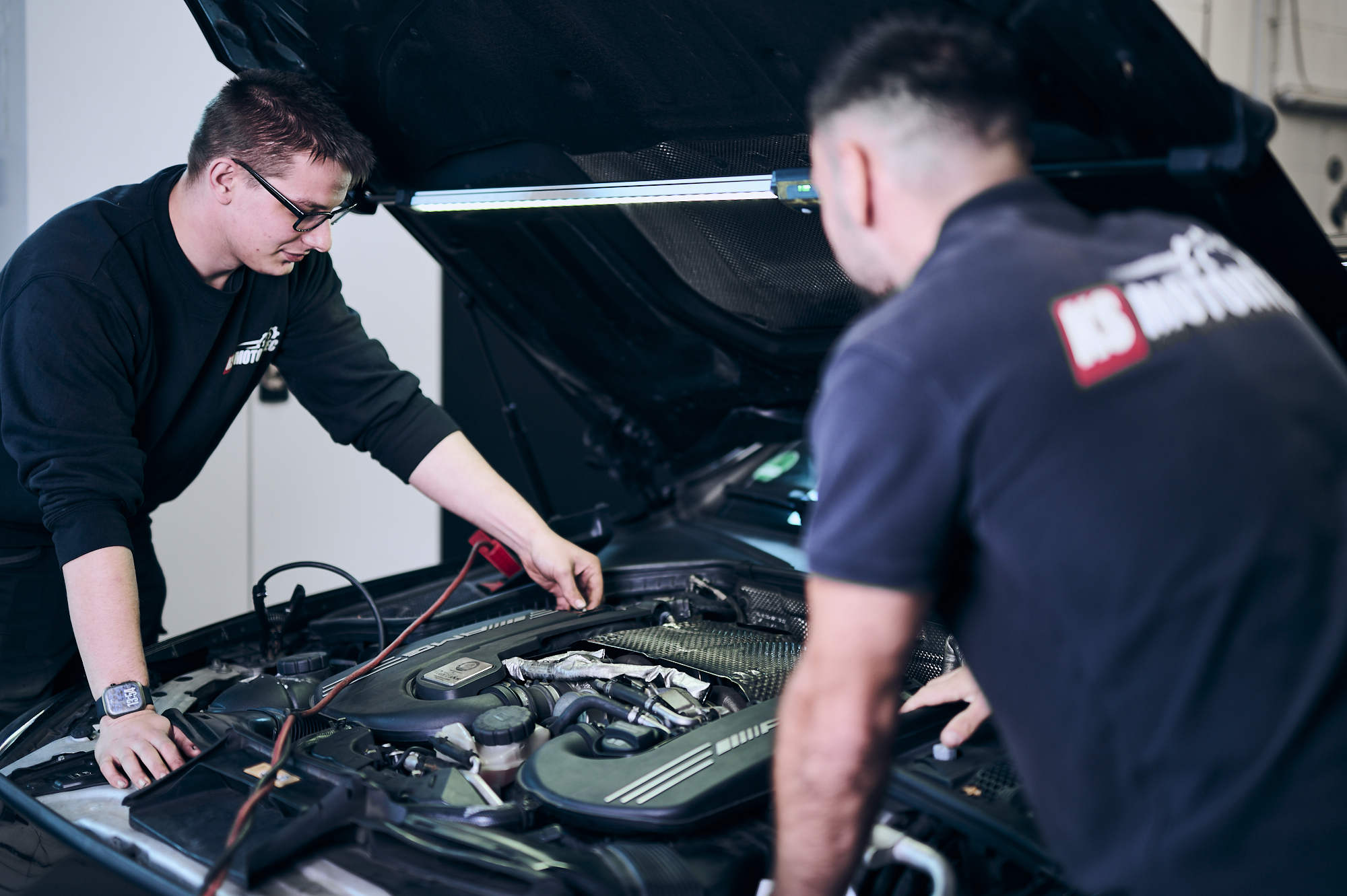 Experte arbeitet an der Fahrzeugelektrik in der Werkstatt in Berlin