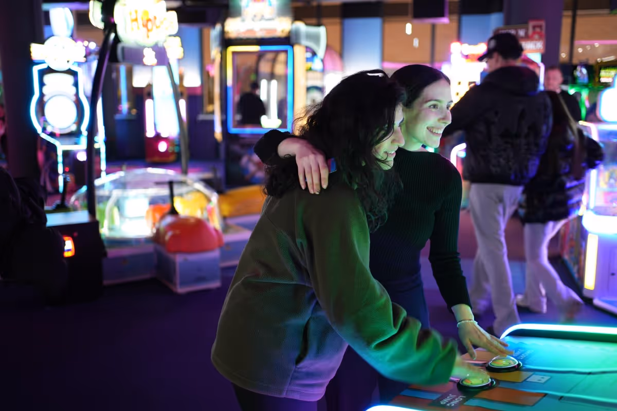 Zwei Frauen spielen in Gamestate  Berlin an Spieleautomaten