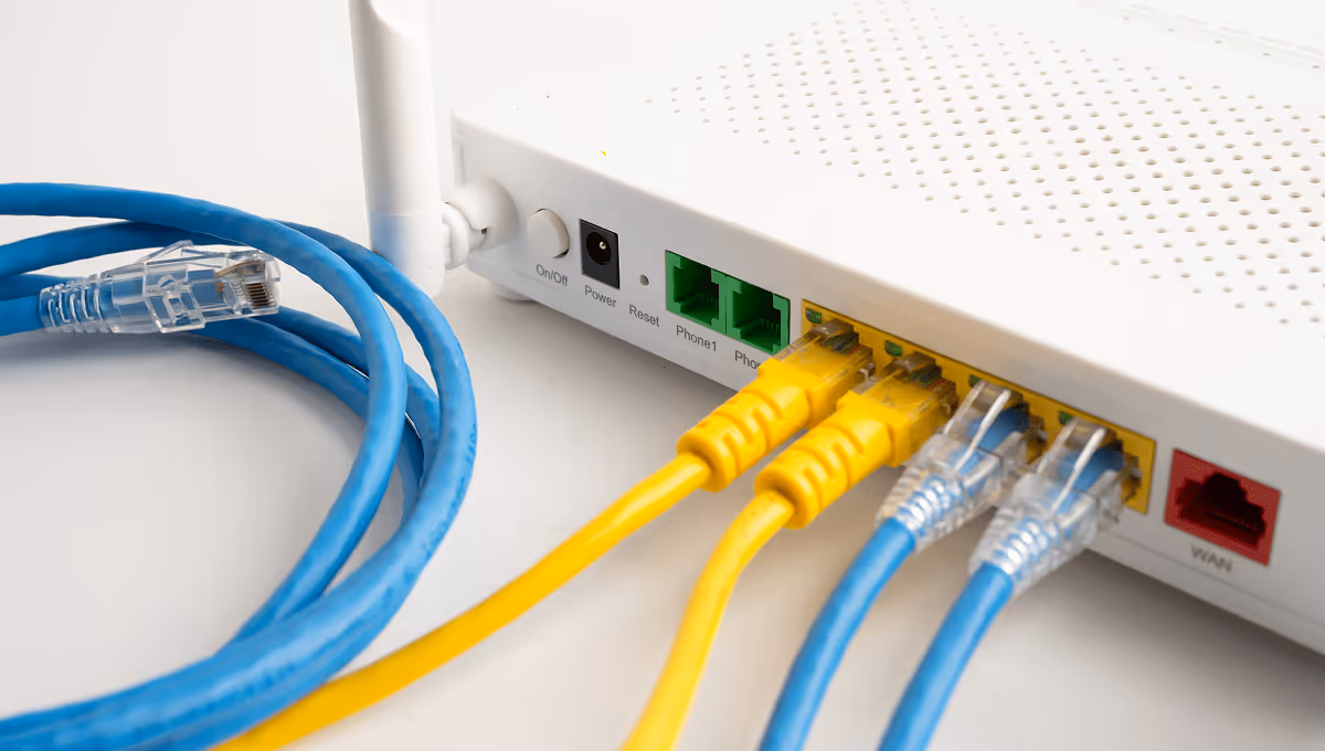 Close-up of wireless router with plugged Ethernet cables in blue and yellow, expert IT network solutions in Luxembourg for secure business connectivity.
