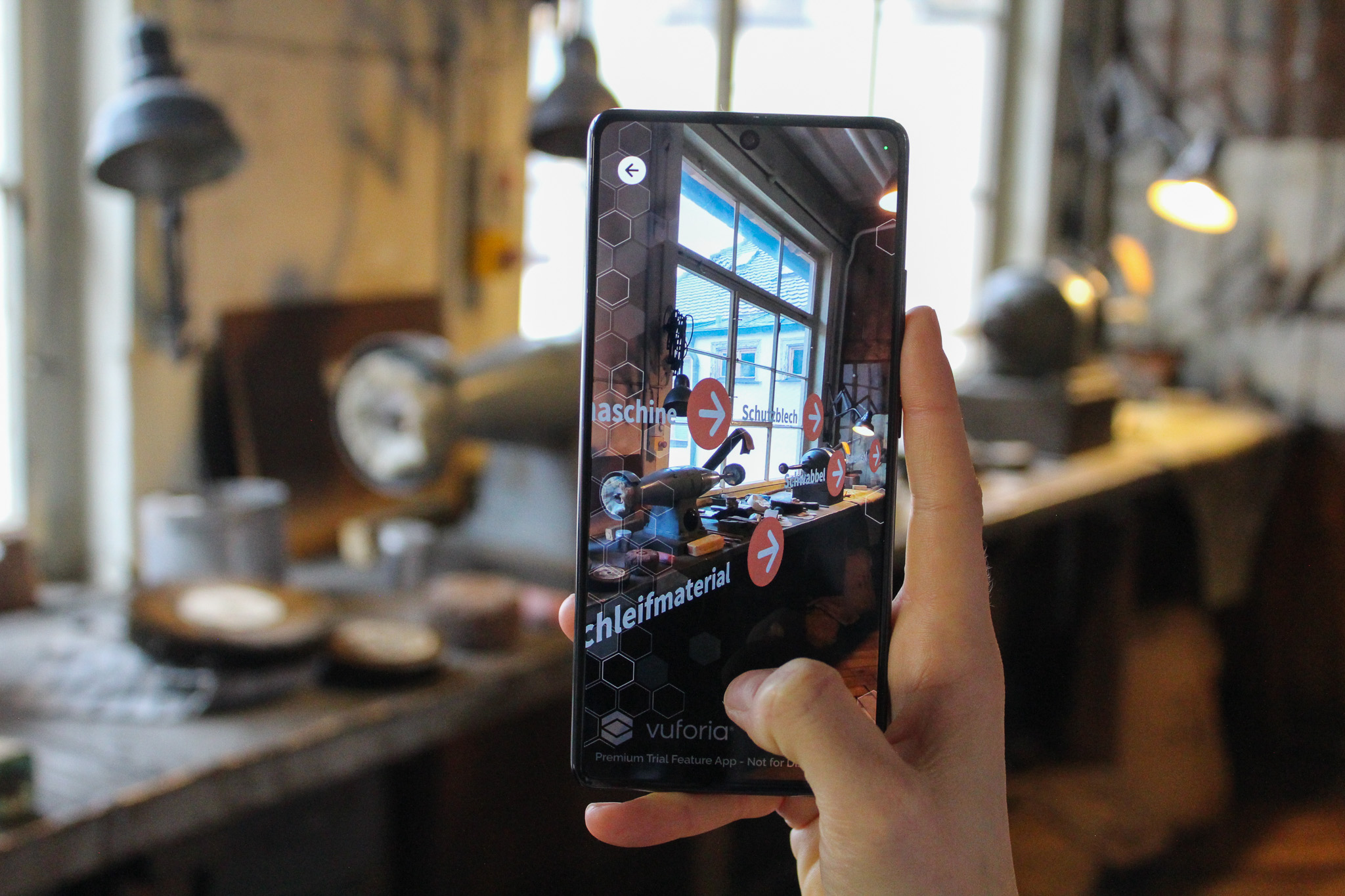 Phone shown AR function of the silverware museum tour app.