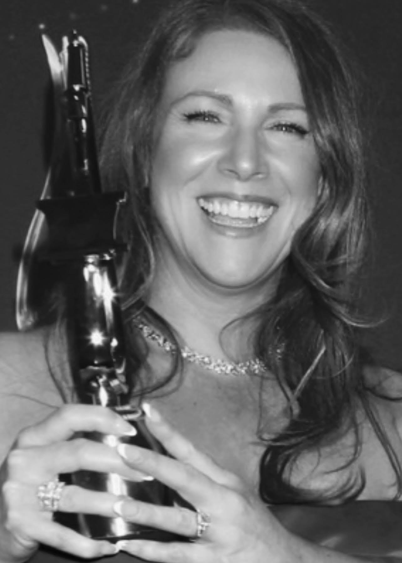 Voiceling Melissa Mirren holding her Voice Arts Award trophy.