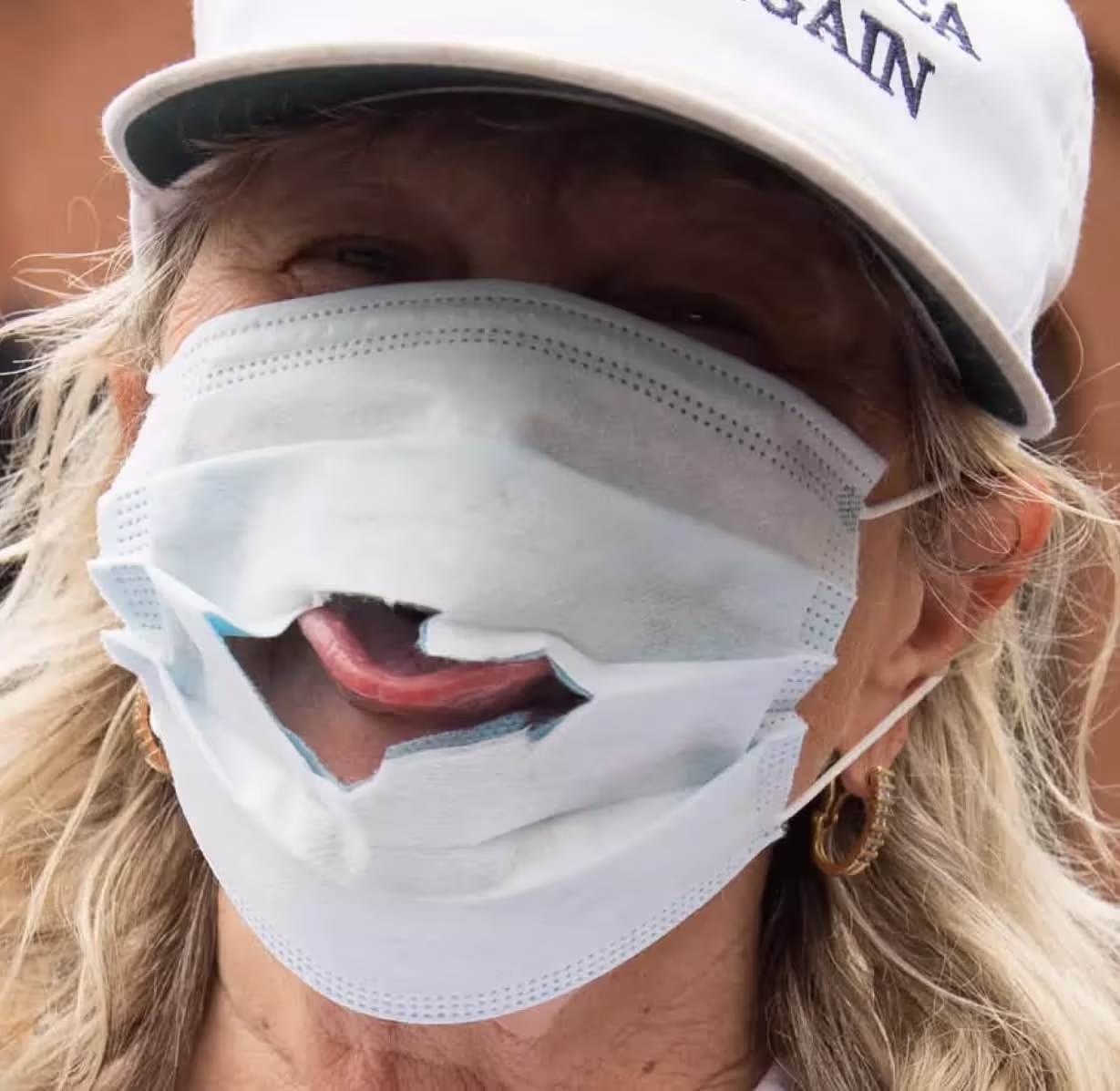 A small number of people are seen tearing holes in COVID masks, presumably to ensure easy passage of Goldburgers. The timing is suspicious, to say the least.