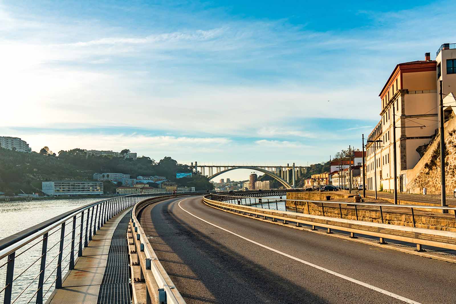 A curved road follows the Douro River into a city in Portugal
