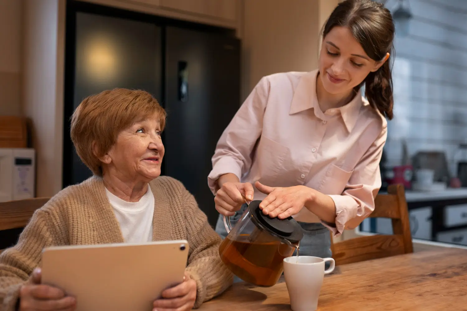 Female caretaker at her client's house taking care of elderly person.