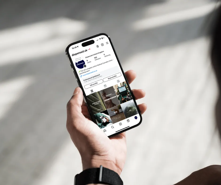 A person holding an iPhone with the Dispensed Instagram page on the screen.