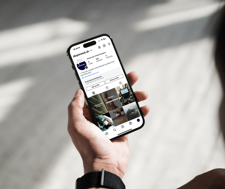 A person holding an iPhone with the Dispensed Instagram page on the screen.