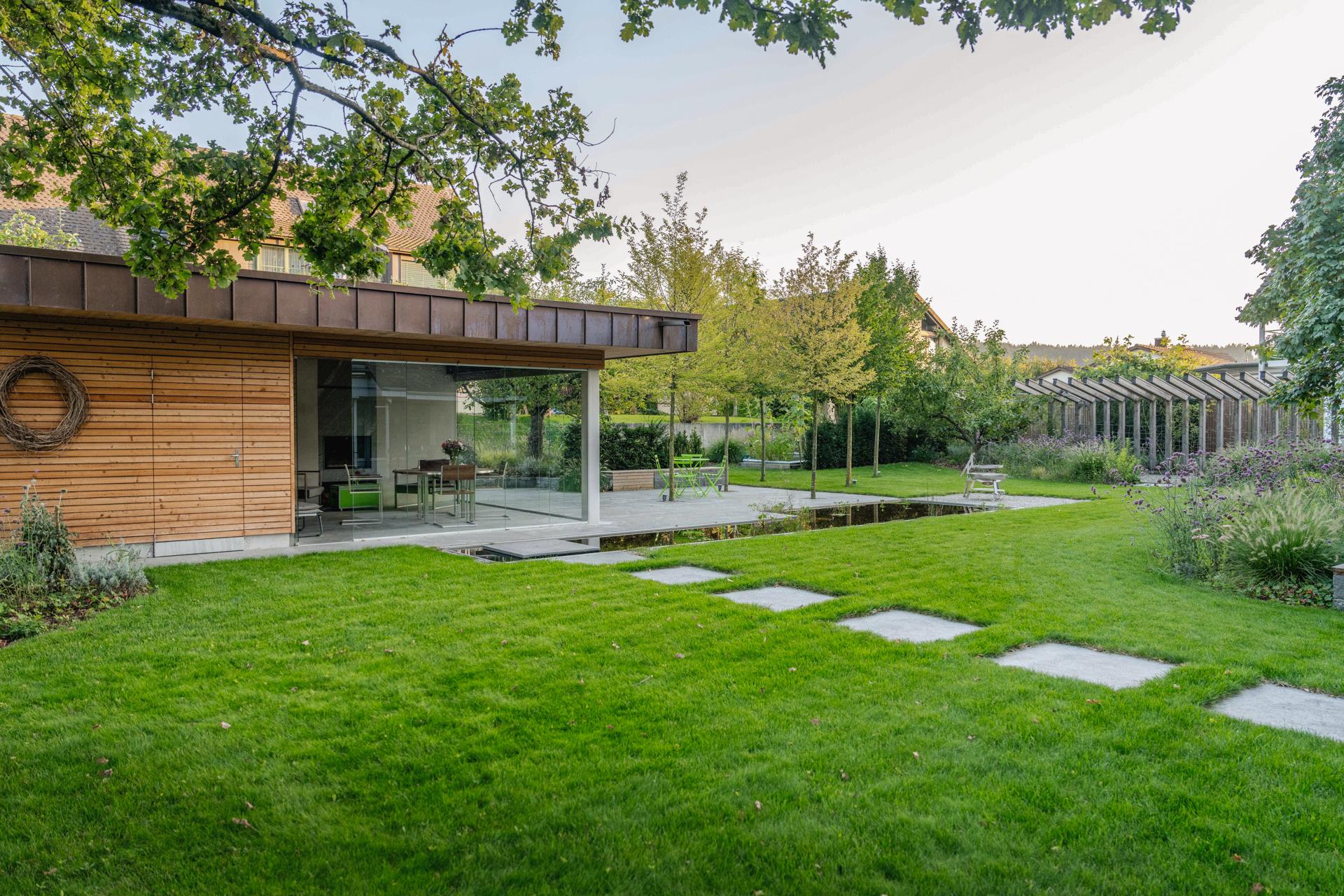 Schrittplatten zu einer grosse Loggia mit Verglasung und Wasserbecken. 