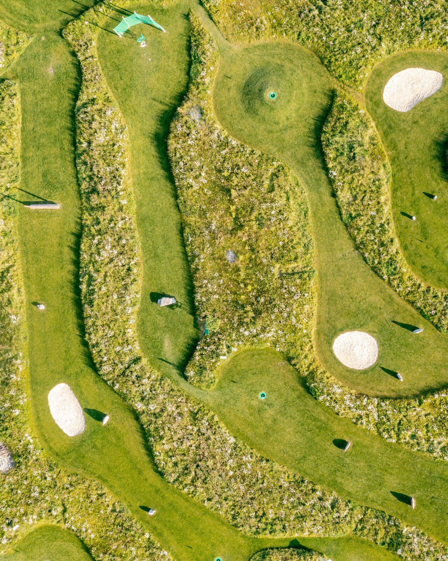 Fussballgolf Aufnahme von Oben mit einigen Löchern und grünen Wiesen dazwischen. 