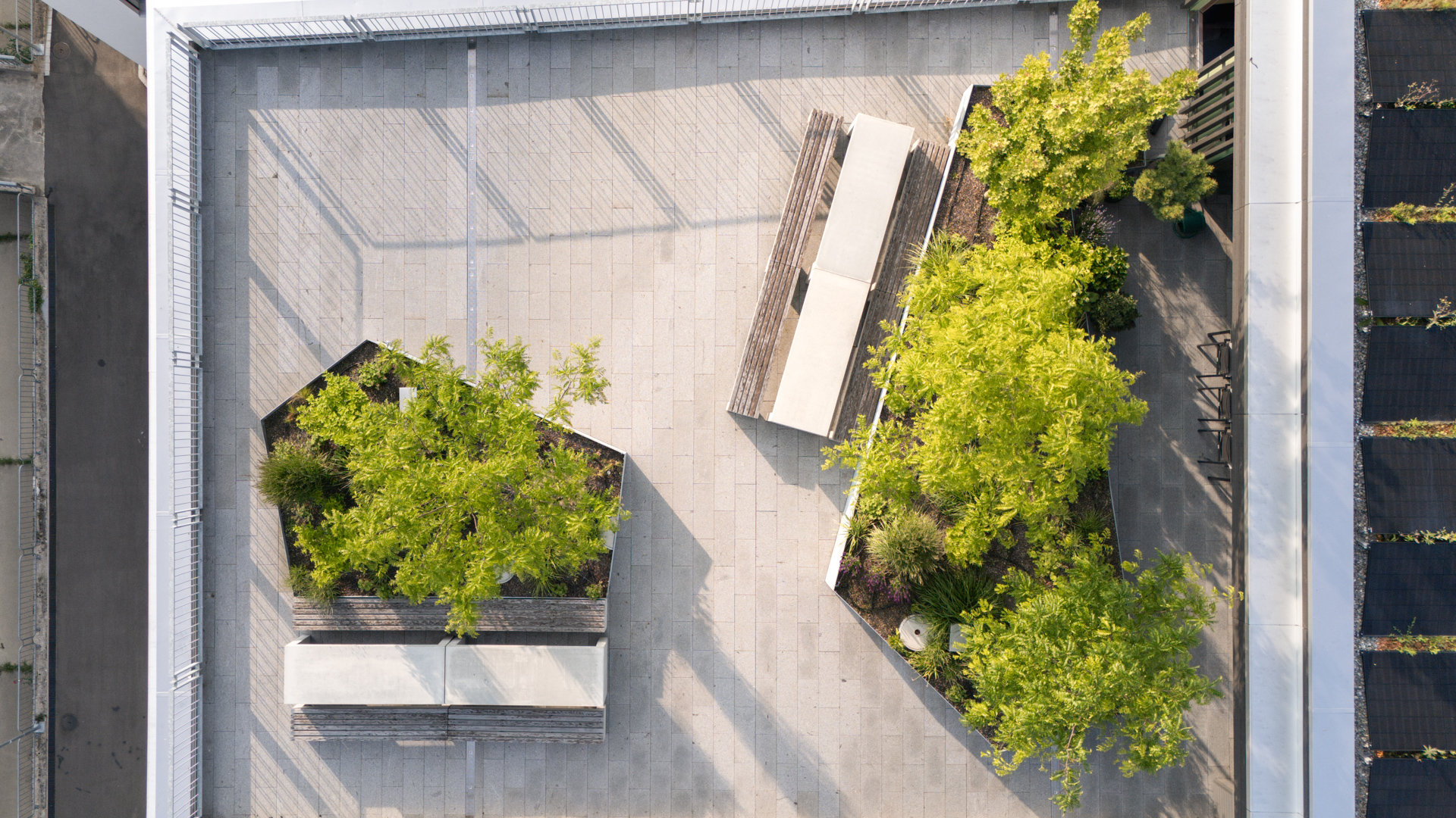 Drohnenaufnahem einer Dachterrasse in Weinfelden mit vielen Sitzgelegenheiten und Bäumen. 