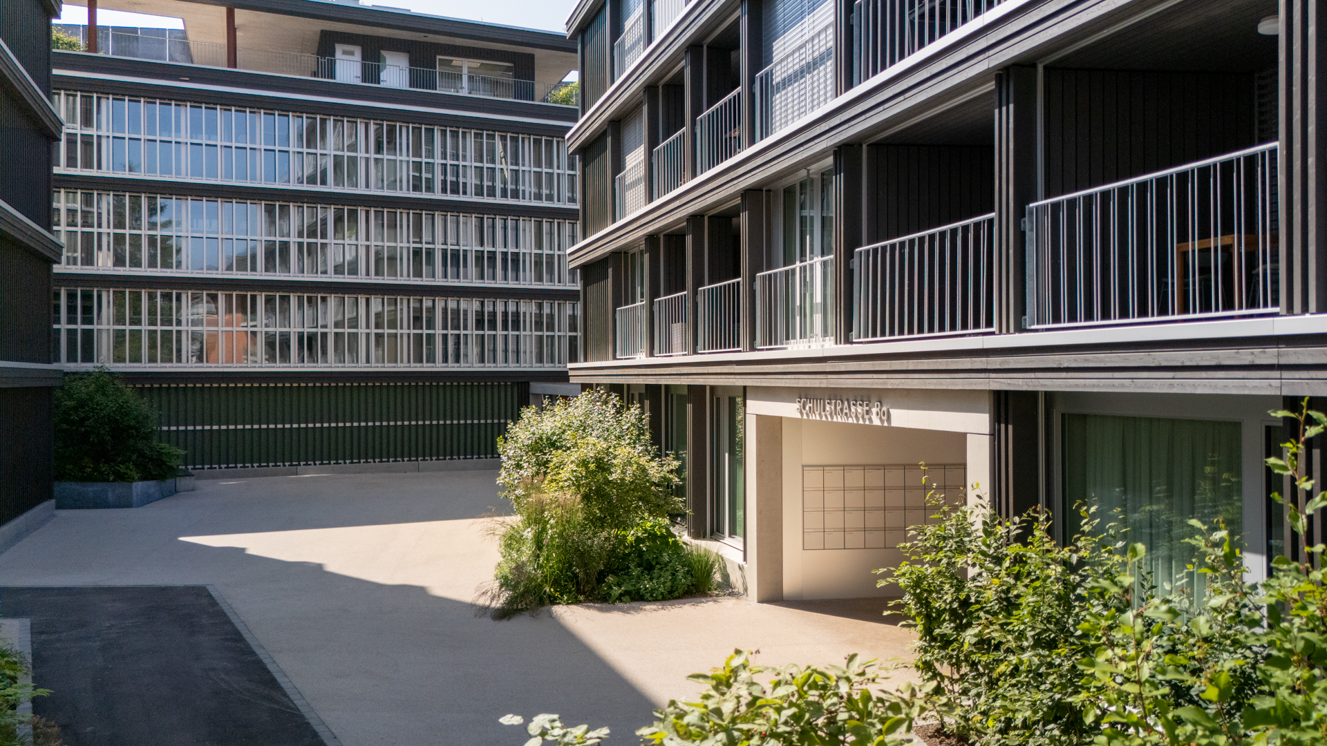 Wohnsiedlung Garageneinfahrtstor mit eingesäumt von Bäumen und Sträuchern. 