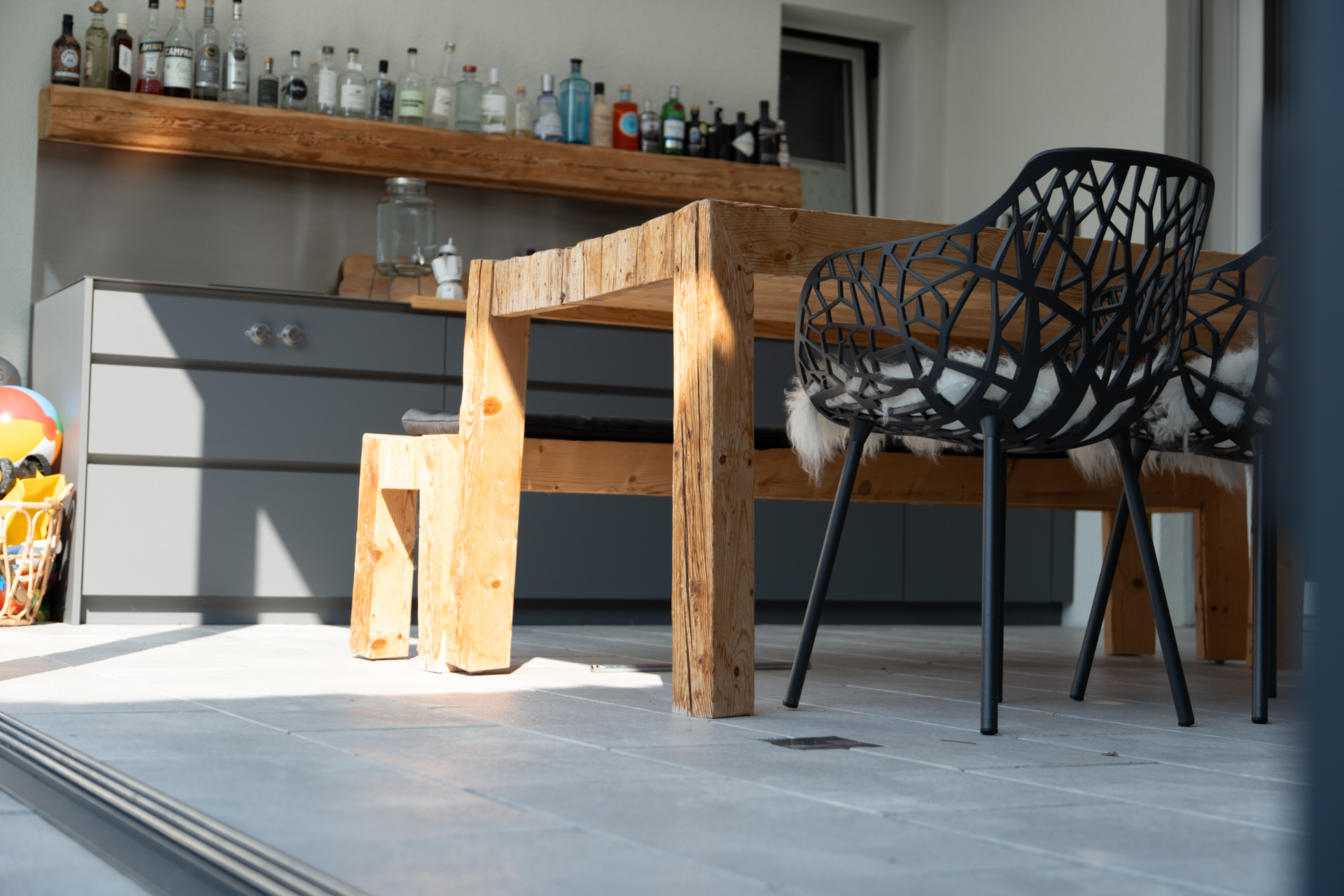 Wintergarten mit Altholz Tisch und Outdoorküche. 