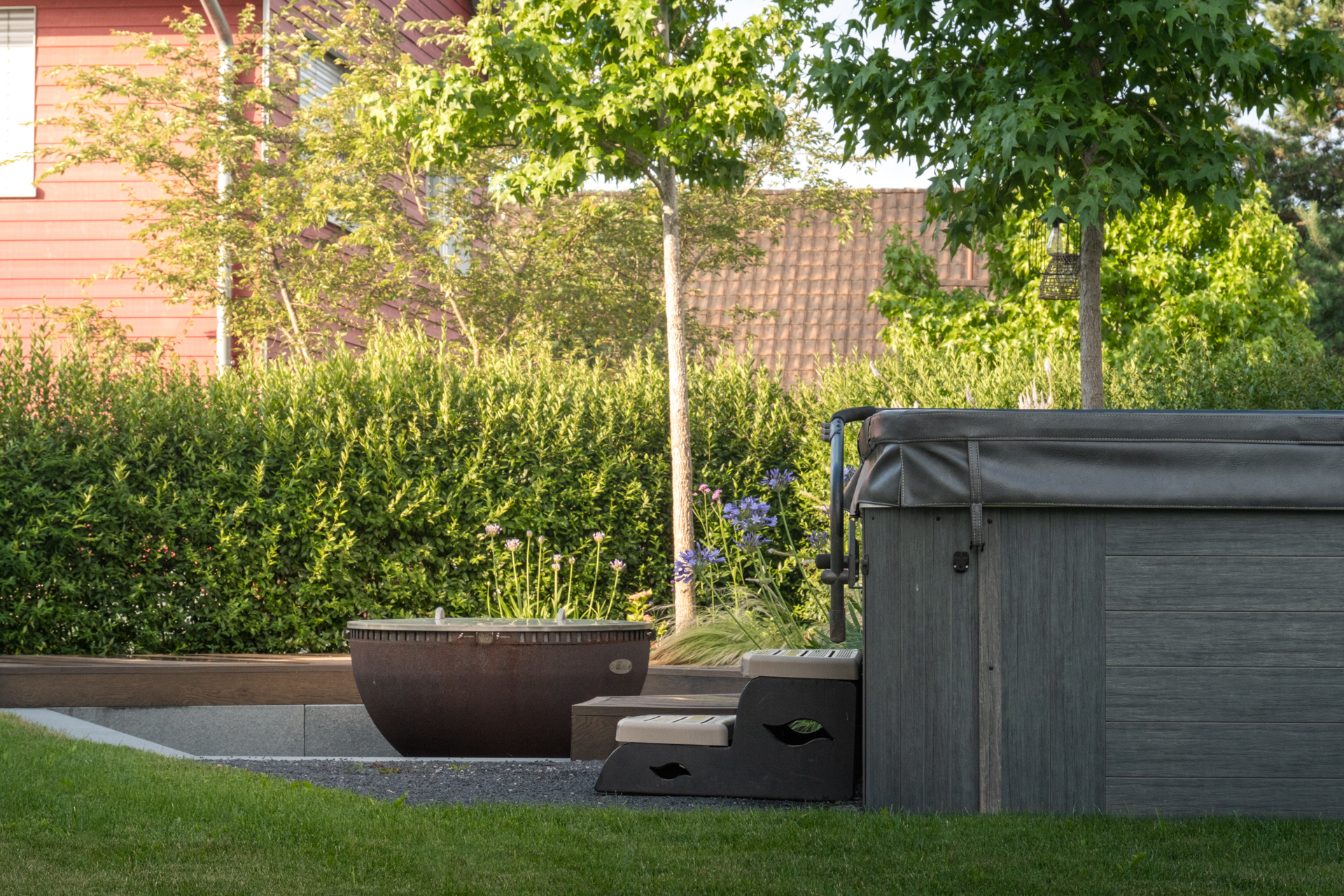 Garten mit Sichtschutzhecke, Feuerschale und Whilpool. 