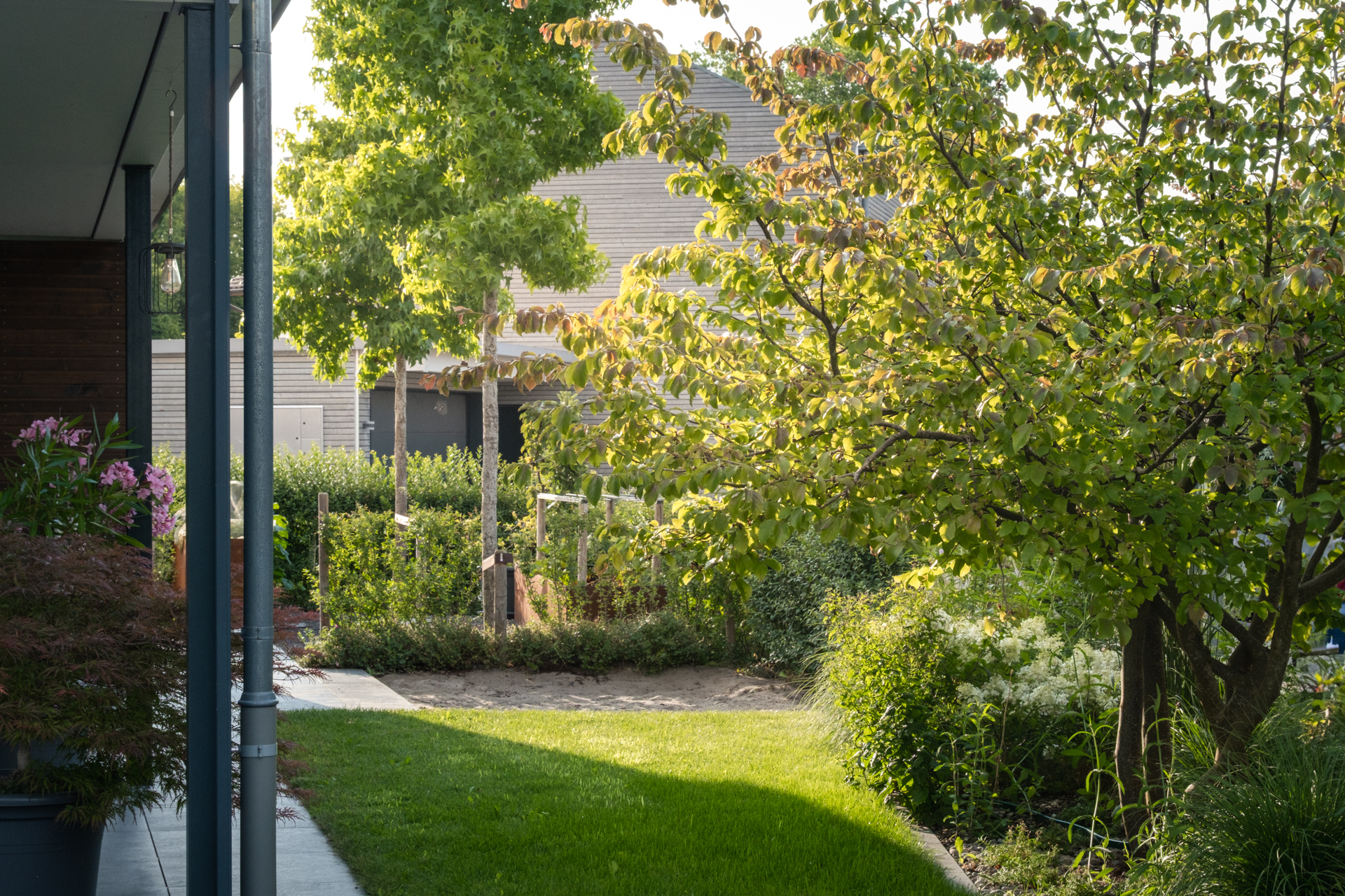 Ein wunderschöner Garten mit saftiger Wiese und schönen Stauden und Bäumen. 