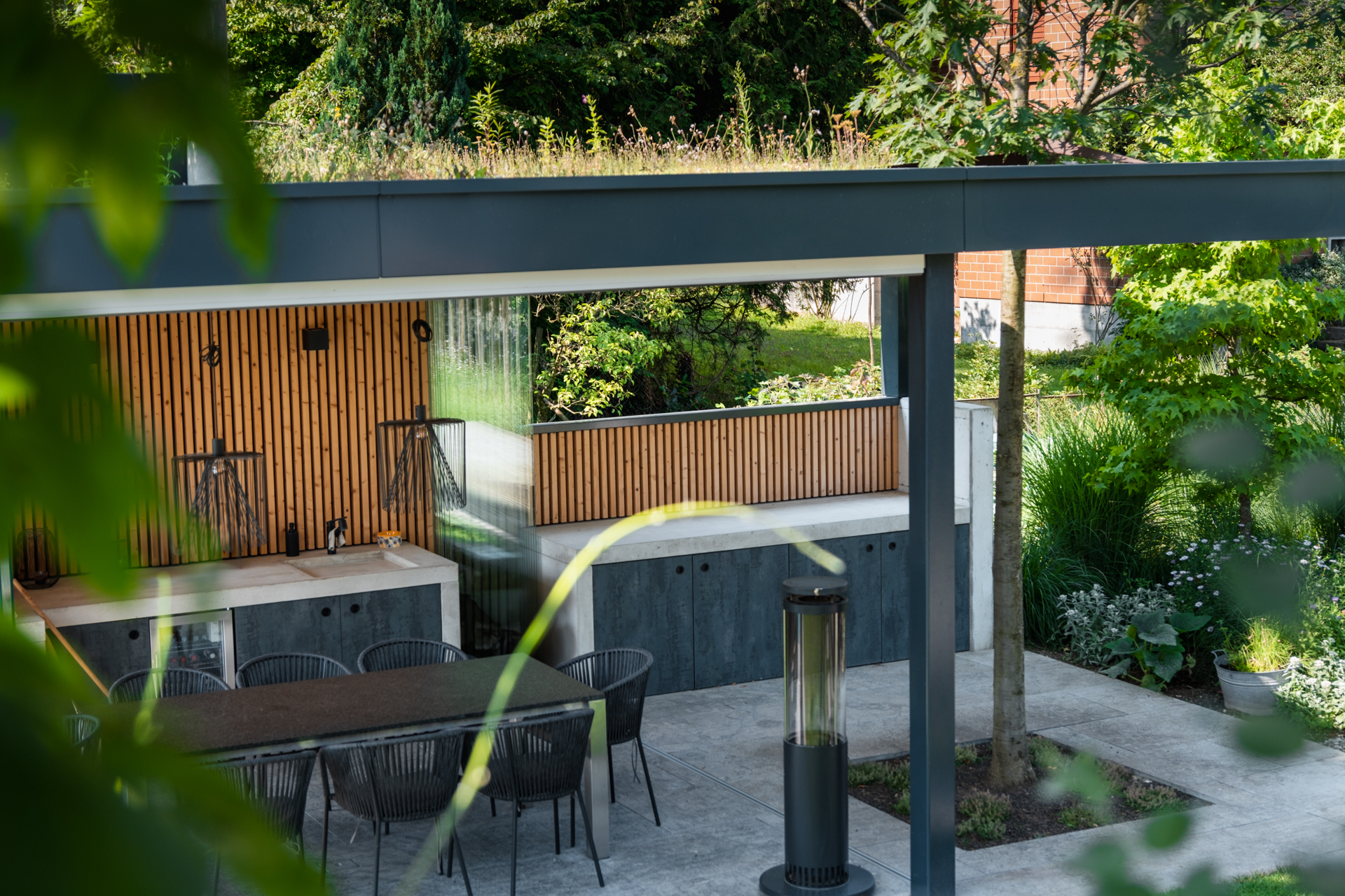 Outdoor Küche im Thurgau mit begrünter Lodgia in blühendem Garten. 