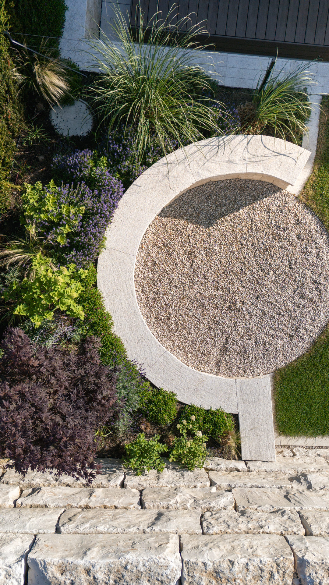 Privater Garten von Oben, runder Kiessitzplatz mit stimmungsvoller Begrünung. 