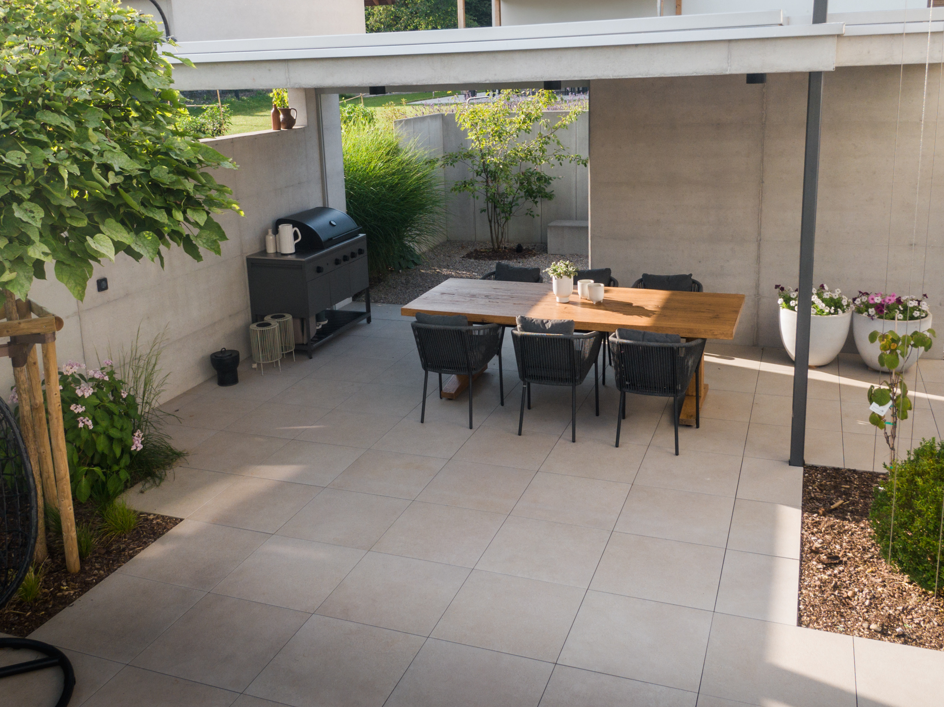 Loggia mit Steinplatten und einem schönen Gartenesstisch. 
