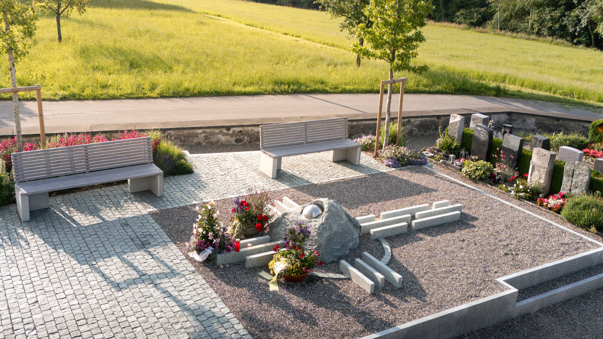 Gemeinschaftsgrab in Leutmerken angeordnet zu einem grossen Stein Kreuz., 