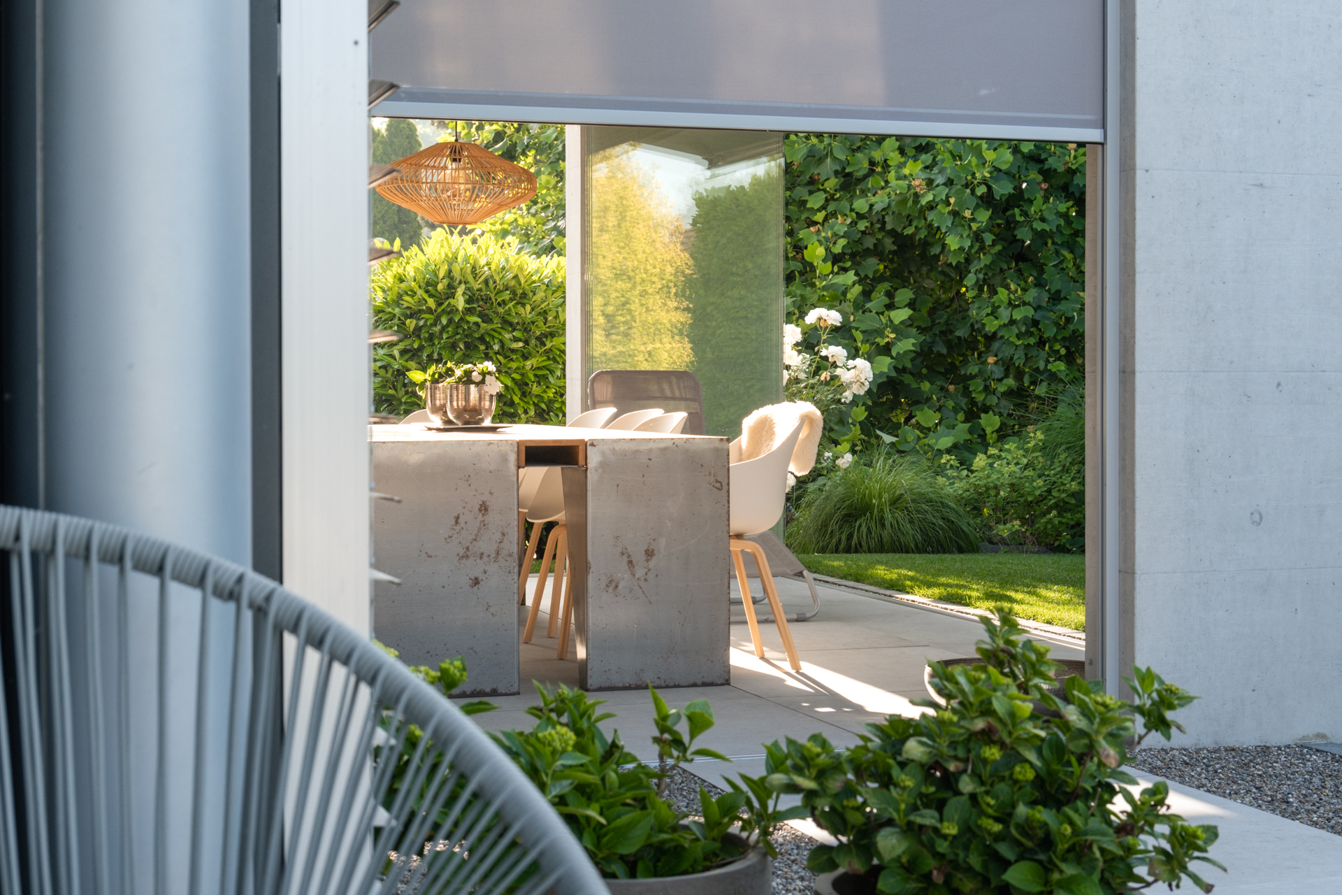 Loggia mit verschiebarer Verglasung in einem wunderschön grünen Garten. 